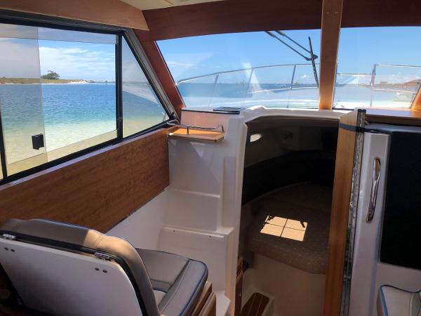 Slide: The Image of Interior view of 2025 Cutwater C-32 Sedan boat with ocean backdrop. - 19