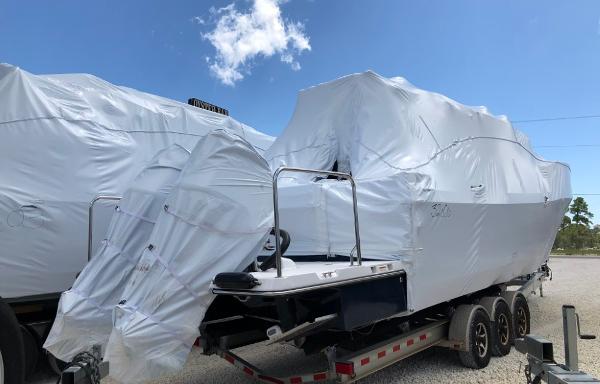 Slide: The Image of 2025 Cutwater C-32 Sedan boat covered on trailer under clear blue sky. - 23