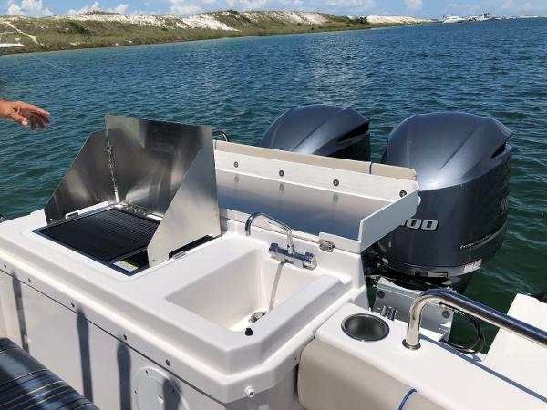 Slide: The Image of Cutwater C-32 Sedan 2025 boat with outdoor sink and grill, dual engines, on a sunny day. - 5
