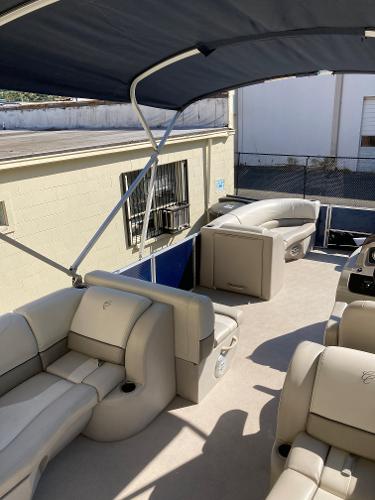 Slide: The Image of 2021 Cypress Cay C232 Tritoon with spacious seating and canopy, docked outdoors. - 10