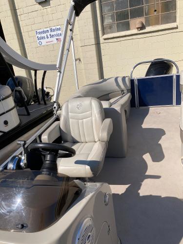 Slide: The Image of 2021 Cypress Cay C232 Tritoon boat interior with beige seating and steering console. - 7