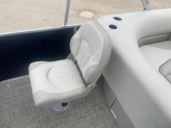 Slide: The Image of 2023 Cypress Cay Seabreeze 212 boat interior with white captain's chair and cup holders. - 6