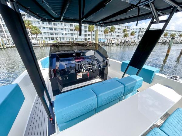 Slide: The Image of 2023 De Antonio Yachts D28 Open with modern helm and seating, docked by waterfront buildings. - 13