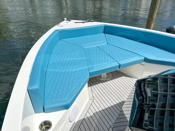Slide: The Image of 2023 De Antonio Yachts D28 Open with blue seating, docked on calm water. - 7