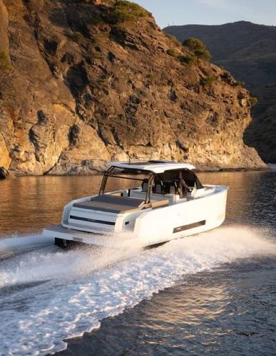 Slide: The Image of 2024 De Antonio Yachts D36 OPEN cruising near rocky coastline. - 2