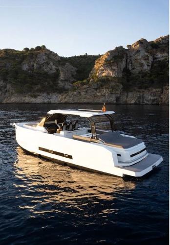 Slide: The Image of 2024 De Antonio Yachts D36 OPEN cruising near rocky coastline at sunset. - 3