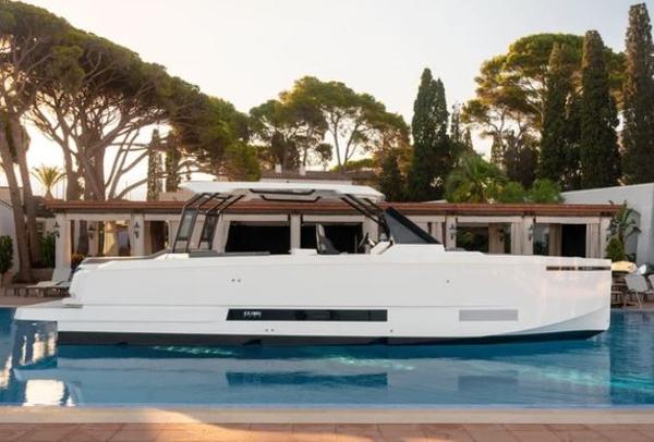Slide: The Image of 2024 De Antonio Yachts D36 OPEN in a serene pool setting, surrounded by lush trees. - 5