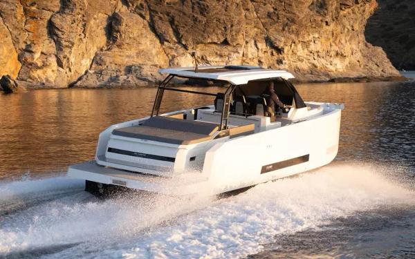 Slide: The Image of 2025 De Antonio Yachts D36 OPEN cruising near rocky coastline at sunset. - 3
