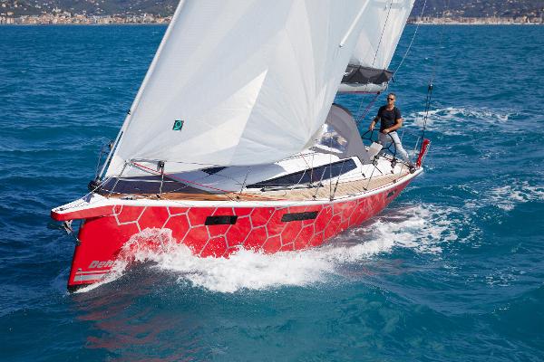 Slide: The Image of 2025 Dehler 38 SQ sailboat with red hull sailing on blue ocean. - 0