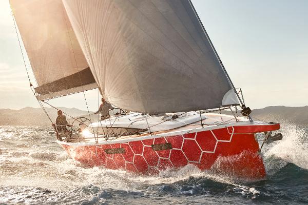 Slide: The Image of 2025 Dehler 38 SQ sailboat with red honeycomb design sailing in open waters. - 1