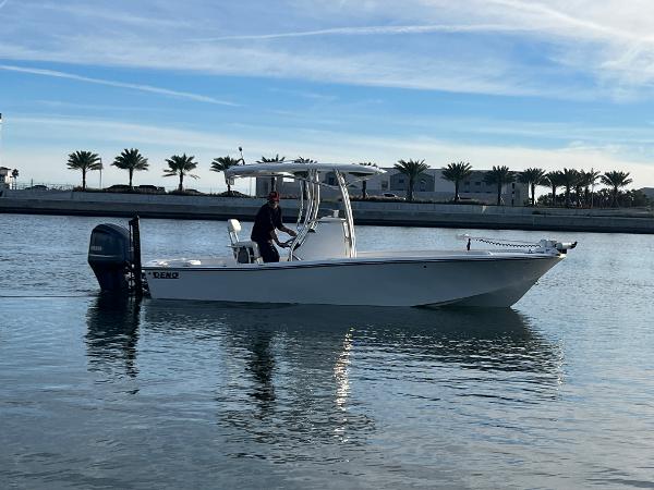 Slide: The Image of 2024 Deno 2400 CC boat cruising on calm water with palm trees in the background. - 12
