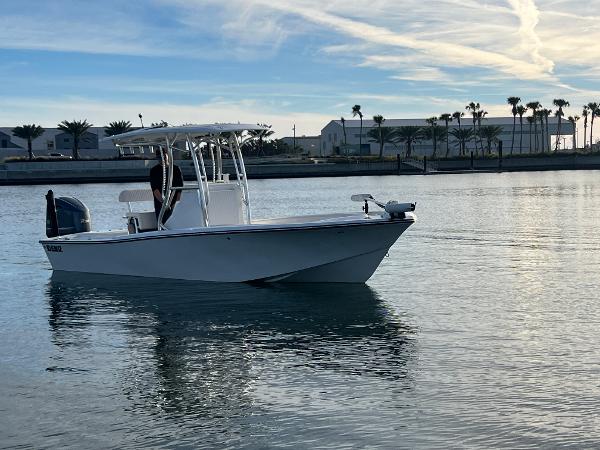 Slide: The Image of 2024 Deno 2400 CC boat cruising on calm waters near a coastal marina. - 13
