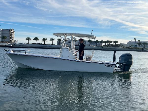 Slide: The Image of 2024 Deno 2400 CC boat on calm water with a person at the helm. - 15