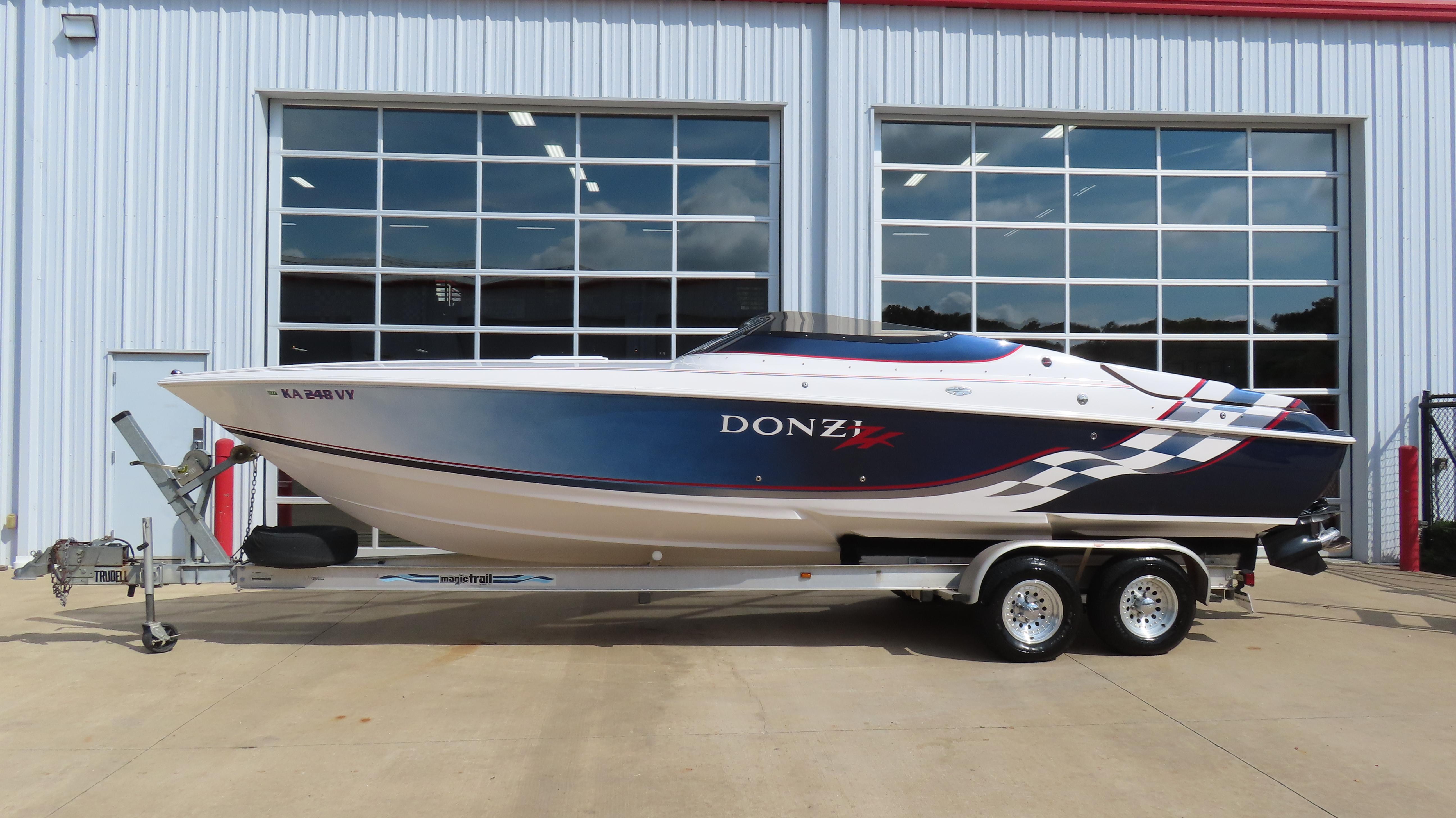 Slide: The Image of 2000 Donzi 28ZX speedboat on trailer, parked outside a garage with large windows. - 1