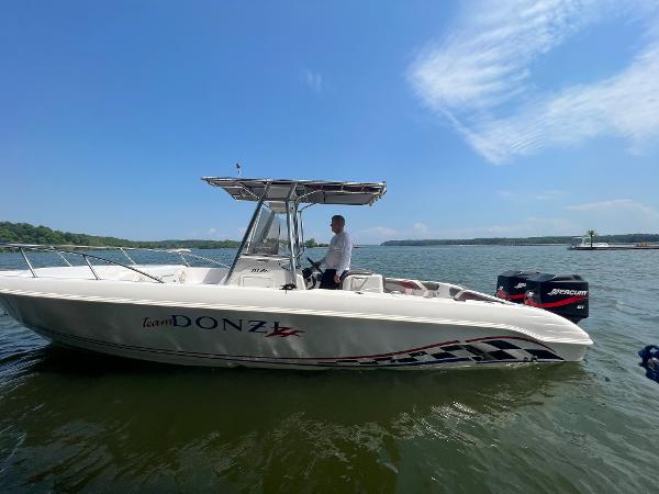 Slide: The Image of 1999 Donzi 30 ZF boat on water with person at helm. - 22