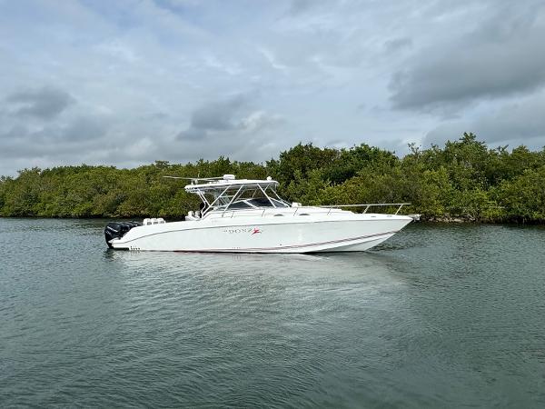 Slide: The Image of 2008 Donzi 38 ZSF boat cruising on a calm waterway with lush greenery in the background. - 1