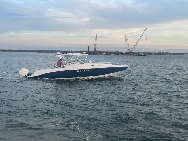 Slide: The Image of 2008 Donzi 38 ZSF boat cruising on open water with cranes in the background. - 17