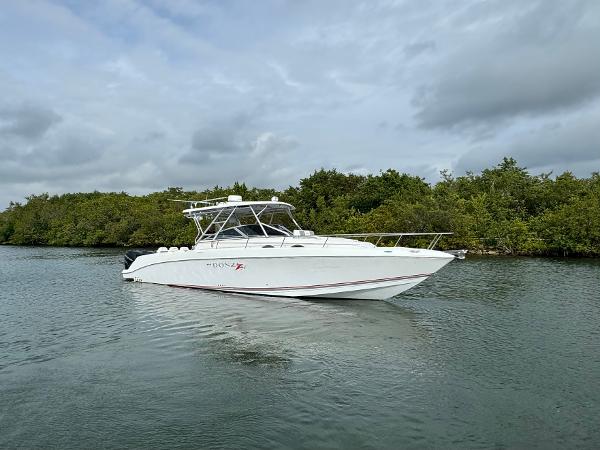 Slide: The Image of 2008 Donzi 38 ZSF boat on calm water with lush greenery in the background. - 2