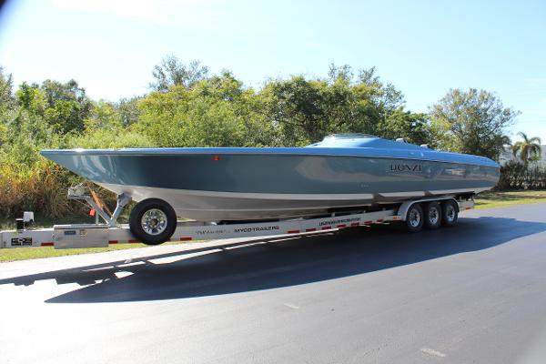 Slide: The Image of 2006 Donzi 43 ZR powerboat on a trailer, parked on a sunny road. - 0