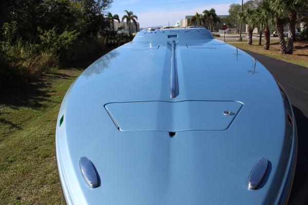Slide: The Image of 2006 Donzi 43 ZR powerboat, sleek blue hull, parked on grass near palm trees. - 15