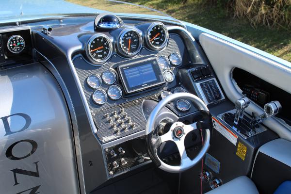 Slide: The Image of 2006 Donzi 43 ZR boat dashboard with gauges, steering wheel, and control panel. - 31