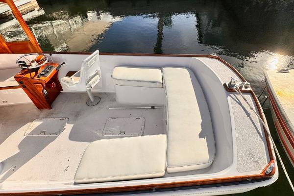 Slide: The Image of 1984 Duffy 20 Hardtop Diesel boat interior with white seating and wooden helm. - 9