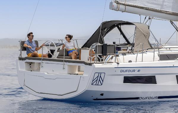 Slide: The Image of 2024 Dufour 41 sailboat on calm waters with two people on deck. - 1