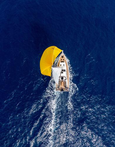 Slide: The Image of Aerial view of 2024 Dufour 41 sailboat with yellow sail on open sea. - 7