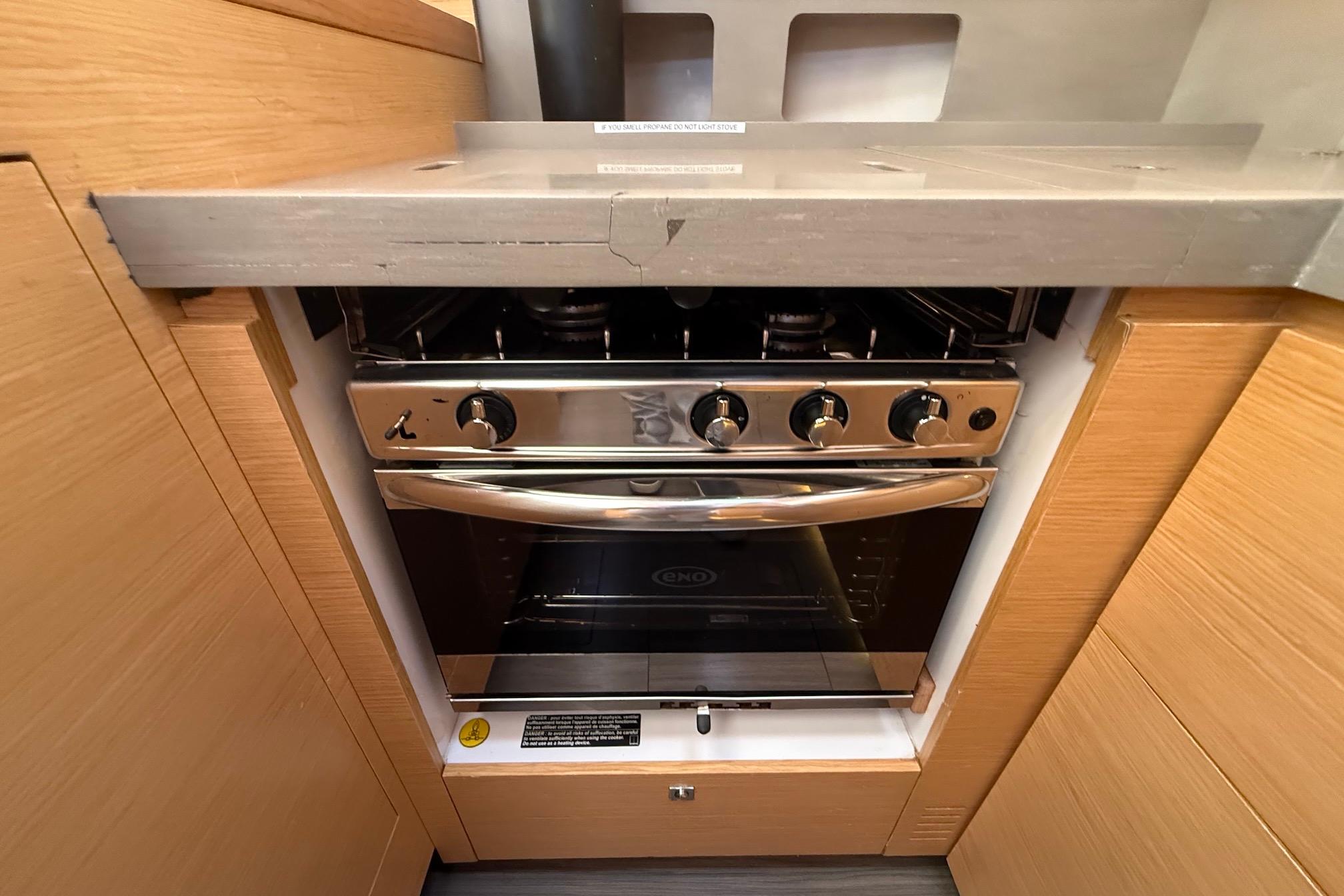 Slide: The Image of Modern kitchen stove in 2022 Dufour 530 yacht, featuring sleek stainless steel design. - 18