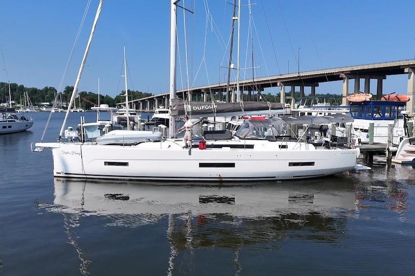 Slide: The Image of 2022 Dufour 530 sailboat docked in a marina, under a clear blue sky. - 2