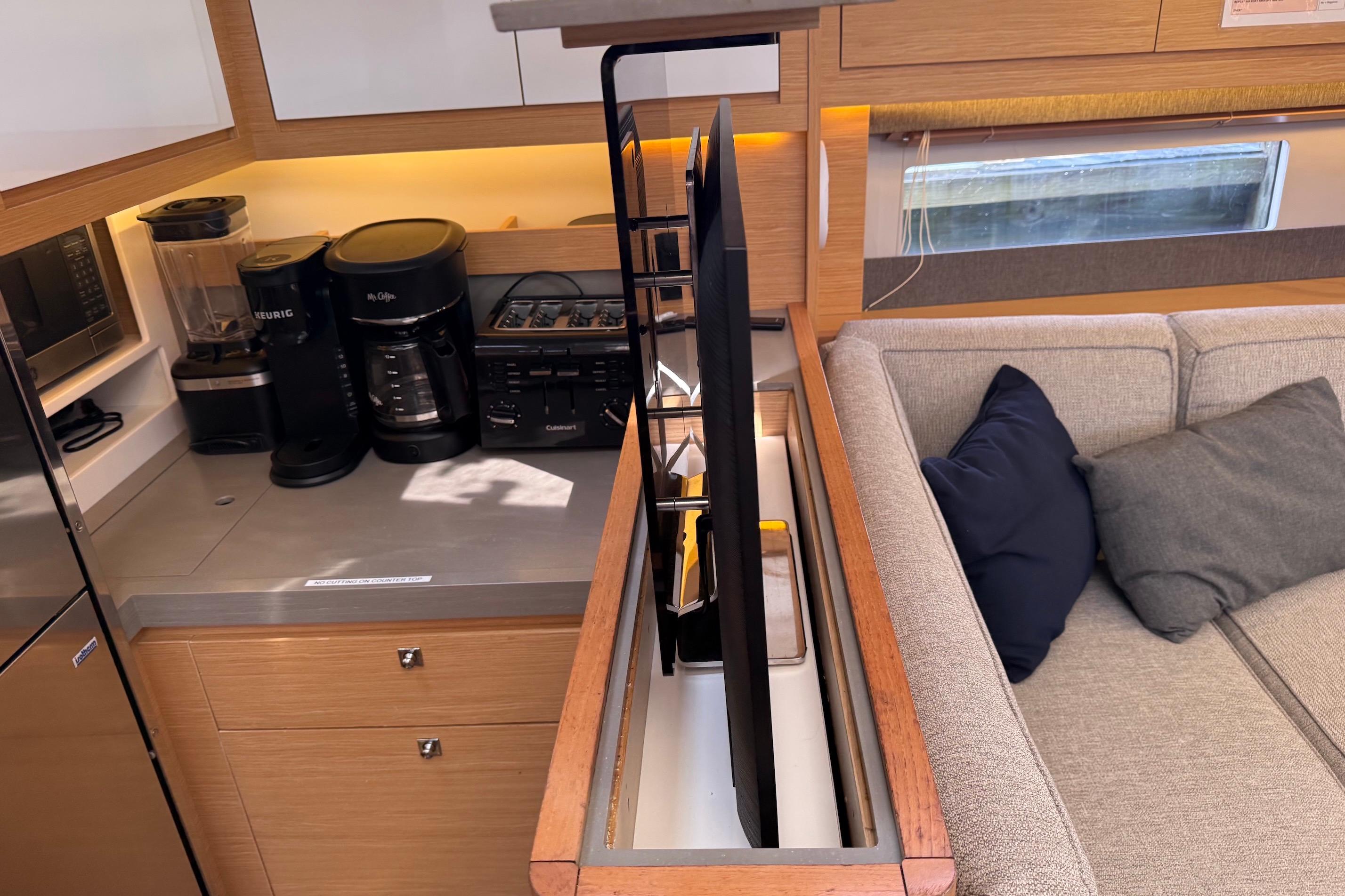 Slide: The Image of Modern kitchen and lounge area in 2022 Dufour 530 yacht, featuring appliances and cozy seating. - 29