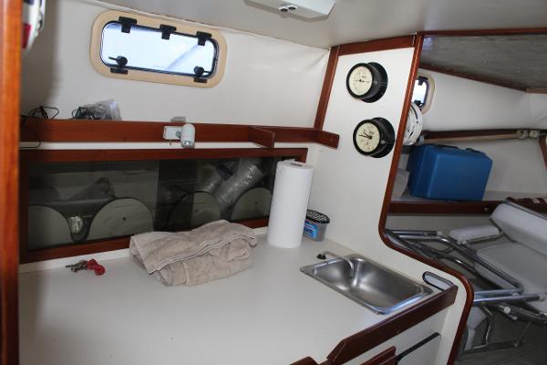 Slide: The Image of 1989 Dyer Downeast boat interior with sink, counter, and storage compartments. - 10