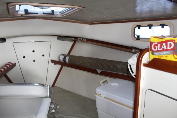 Slide: The Image of 1989 Dyer Downeast boat cabin interior with storage shelves and a cooler. - 15