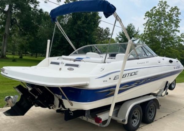 Slide: The Image of 2004 Ebbtide Campione 210 boat on a trailer with blue accents and canopy. - 1