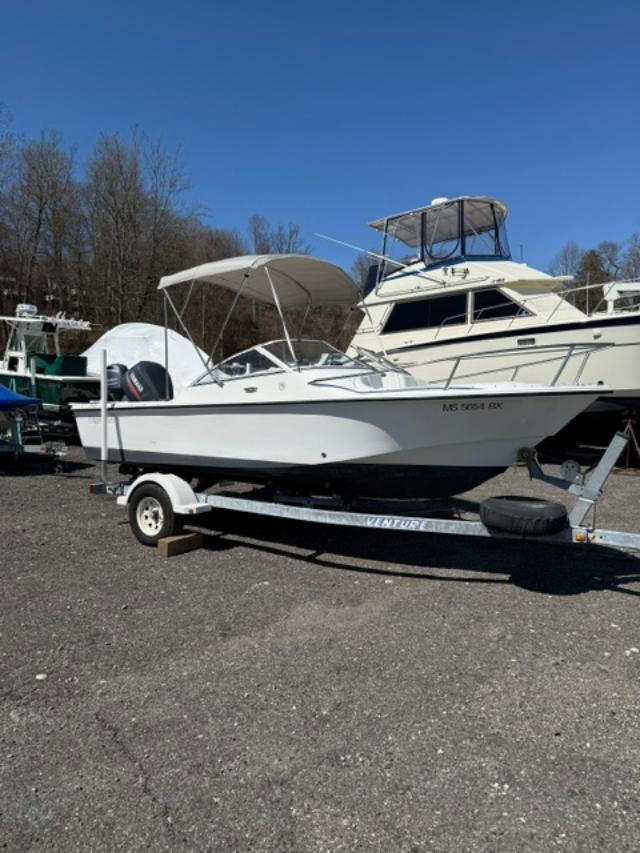 Slide: The Image of 2001 Edgewater 185DC boat on trailer, parked outdoors under clear blue sky. - 1