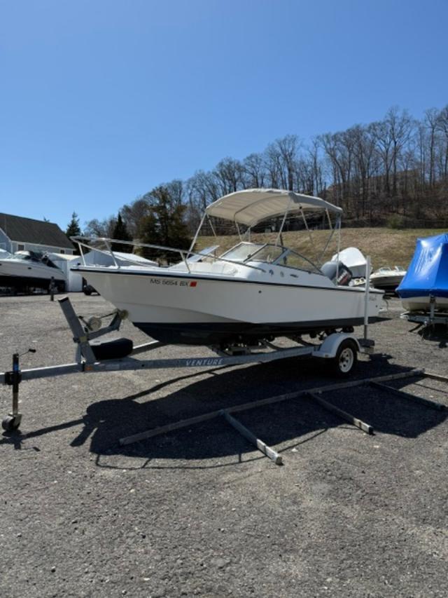 Slide: The Image of 2001 Edgewater 185DC boat on trailer, parked outdoors under clear blue sky. - 2