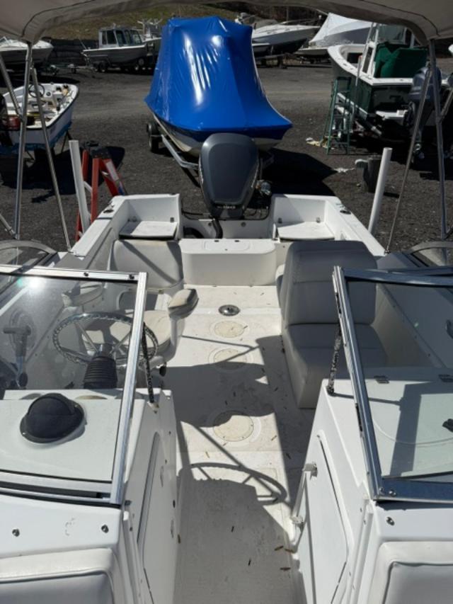 Slide: The Image of 2001 Edgewater 185DC boat interior with seating and steering wheel, parked outdoors. - 3