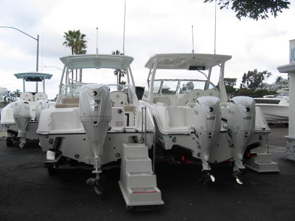 Slide: The Image of 2024 Edgewater 245CX boats with powerful outboard engines in a marina. - 11