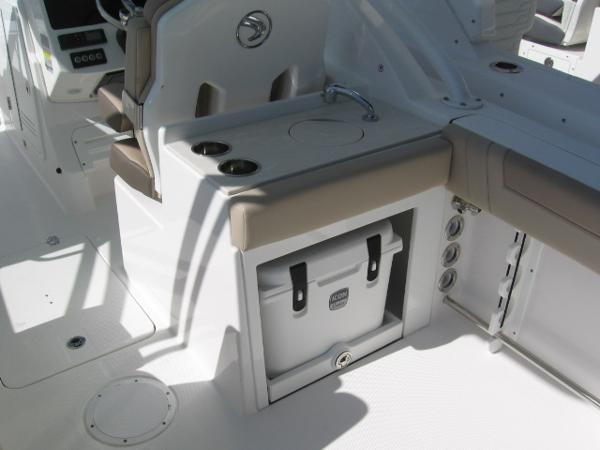 Slide: The Image of 2024 Edgewater 245CX boat interior with sink, cup holders, and cooler storage. - 5