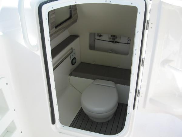 Slide: The Image of 2024 Edgewater 245CX boat interior bathroom with toilet and storage. - 6