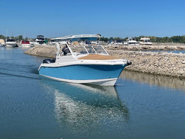 Slide: The Image of 2024 Edgewater 280 CX boat cruising in a marina. - 5
