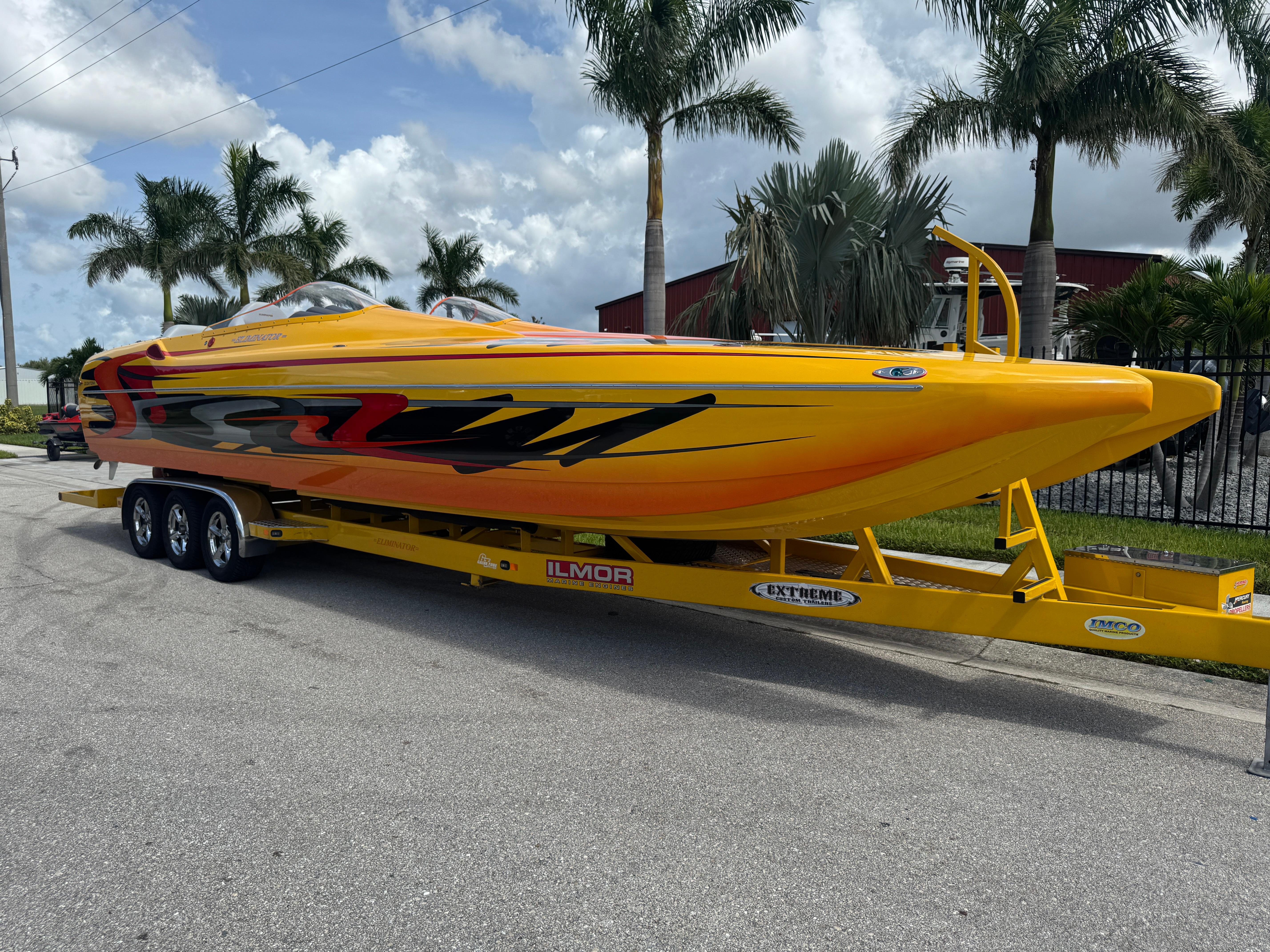 Slide: The Image of 2006 Eliminator 33 Daytona speedboat with vibrant yellow and red design on a trailer. - 1