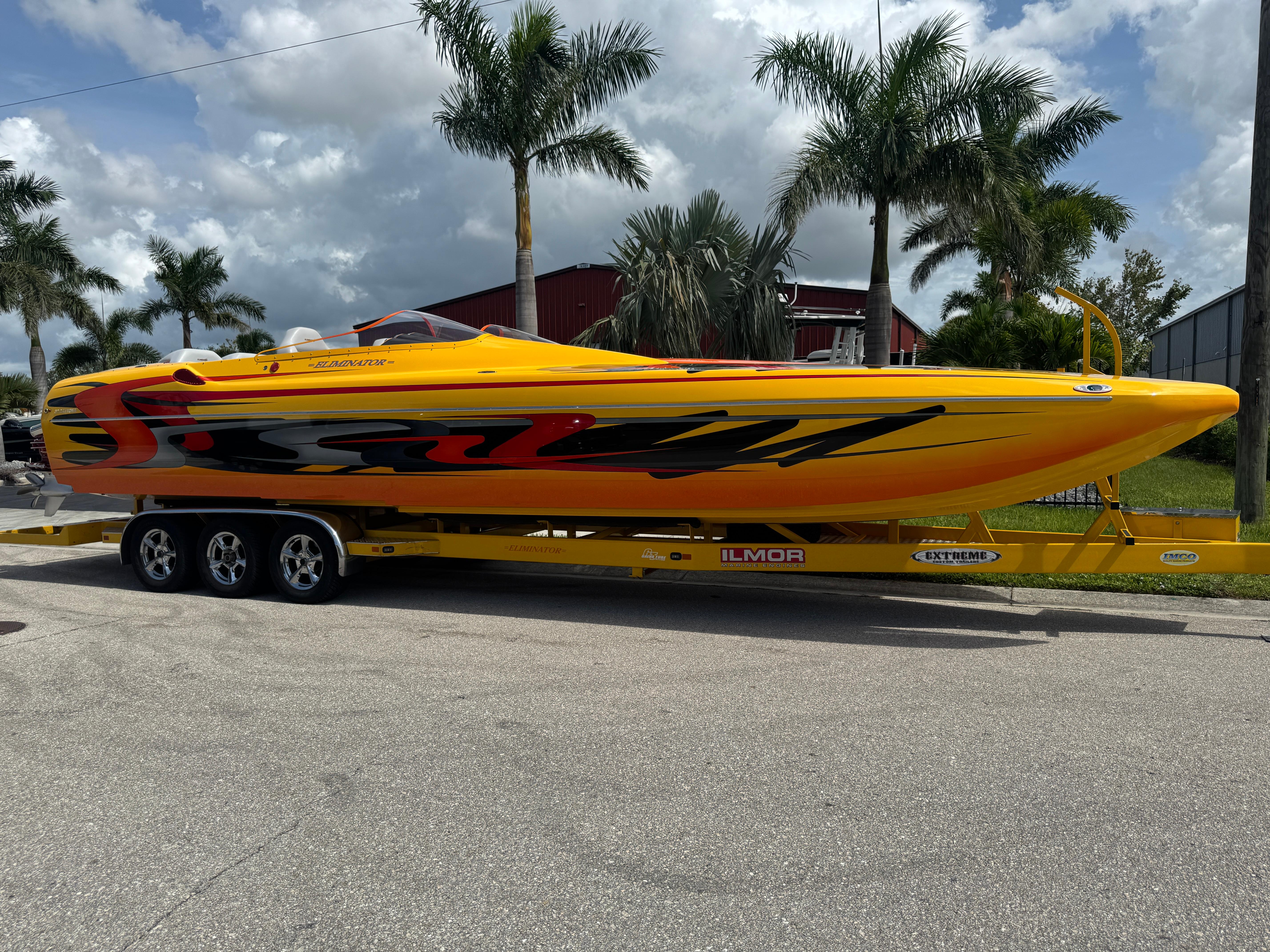 Slide: The Image of 2006 Eliminator 33 Daytona speedboat on trailer, vibrant yellow with red and black graphics. - 2