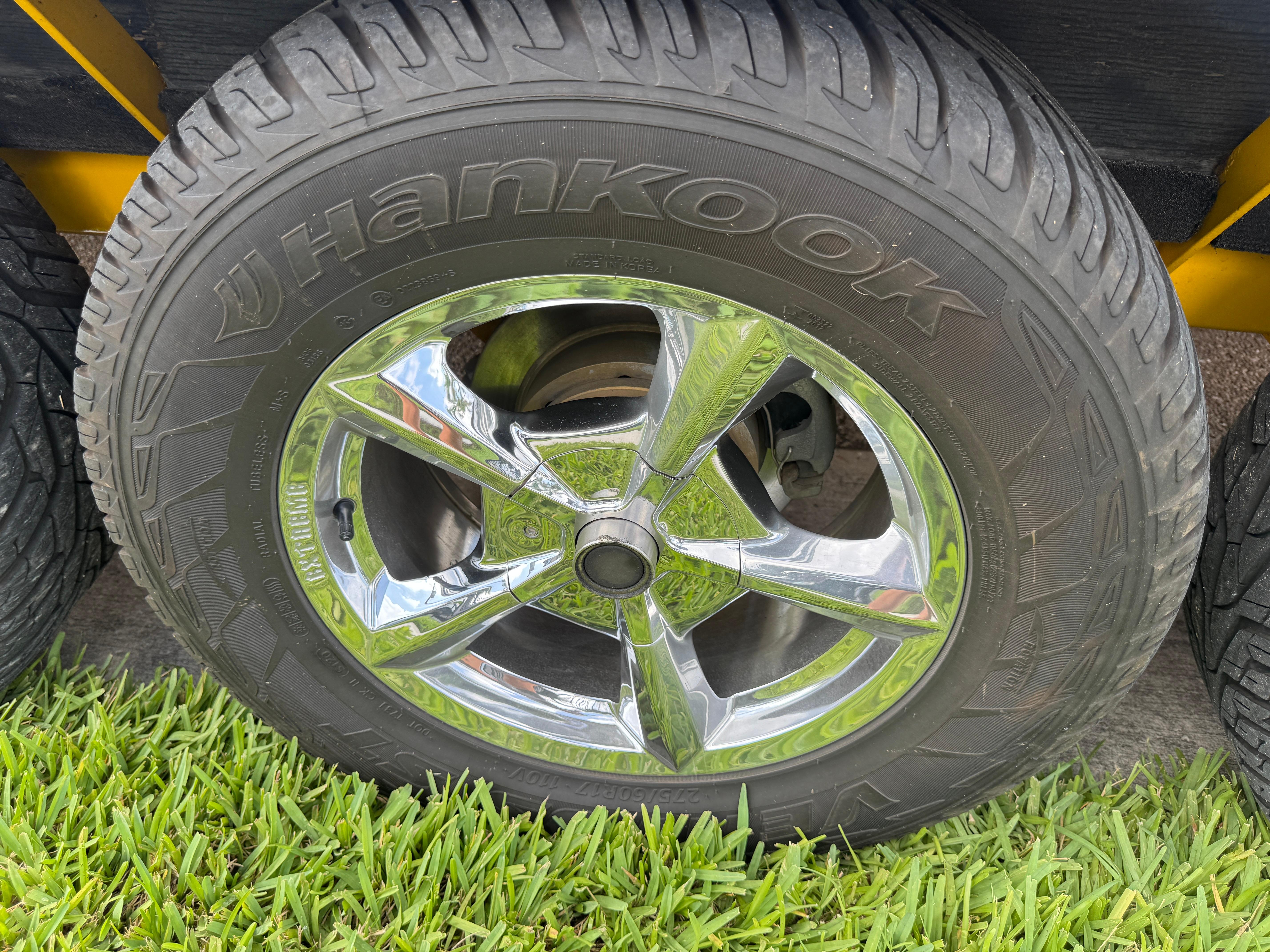Slide: The Image of Chrome wheel with Hankook tire on 2006 Eliminator 33 Daytona, parked on grass. - 8