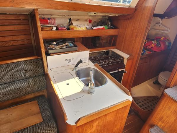 Slide: The Image of Compact kitchen area in a 1984 Elite 32 sailboat with sink, stove, and storage. - 5