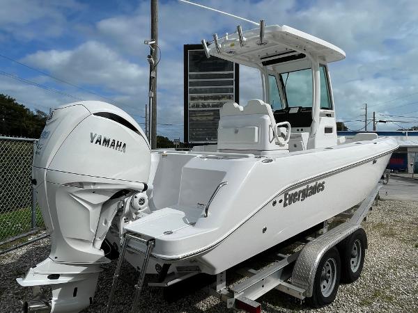 Slide: The Image of 2023 Everglades 235CC boat on trailer with Yamaha engine, parked outdoors. - 1