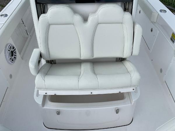 Slide: The Image of 2023 Everglades 235CC boat with white cushioned seating and storage compartment. - 13