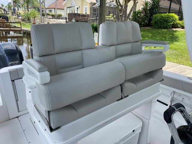 Slide: The Image of 2020 Everglades 255 CC boat with gray leather seats, docked near a residential area. - 6