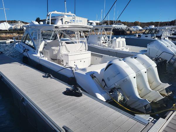 Slide: The Image of 2018 Everglades 360 LXC boat docked at a marina with triple outboard engines. - 1