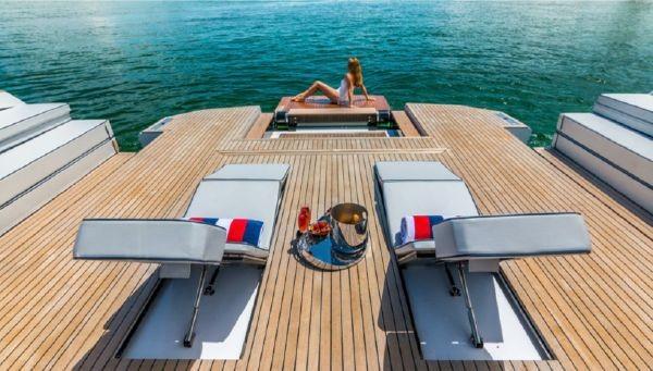 Slide: The Image of Luxury Evo Yachts 43 (2017) with sun loungers and a woman relaxing on deck. - 4